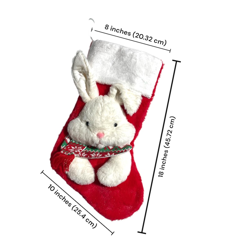 May include: A festive red Christmas stocking featuring a white plush bunny face and ears. The stocking measures 45.72 cm long and 25.4 cm wide, with a white cuff and a decorative scarf. The stocking is 20.32 cm wide.