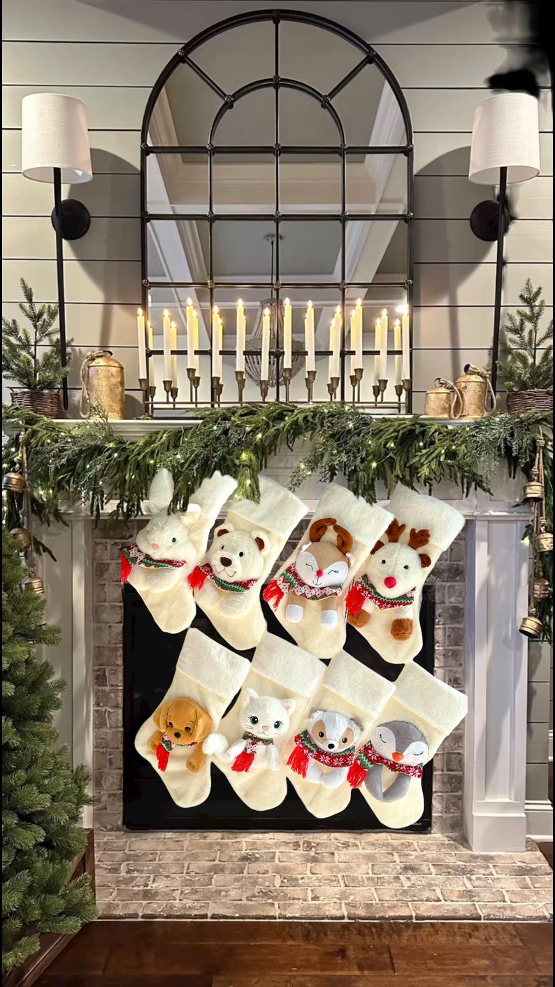 May include: A display of cream Christmas stockings, each featuring a plush animal character such as a rabbit, bear, fox, and reindeer. The stockings are arranged on a fireplace mantel decorated with greenery and candles, creating a festive holiday scene.