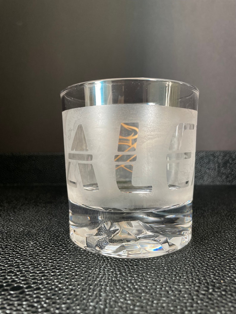 May include: A frosted glass with the word "ALE" etched into the side.