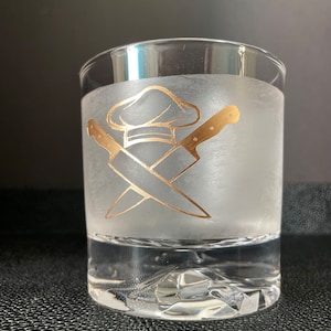May include: A frosted glass with a gold design of crossed chef's knives and a chef's hat.