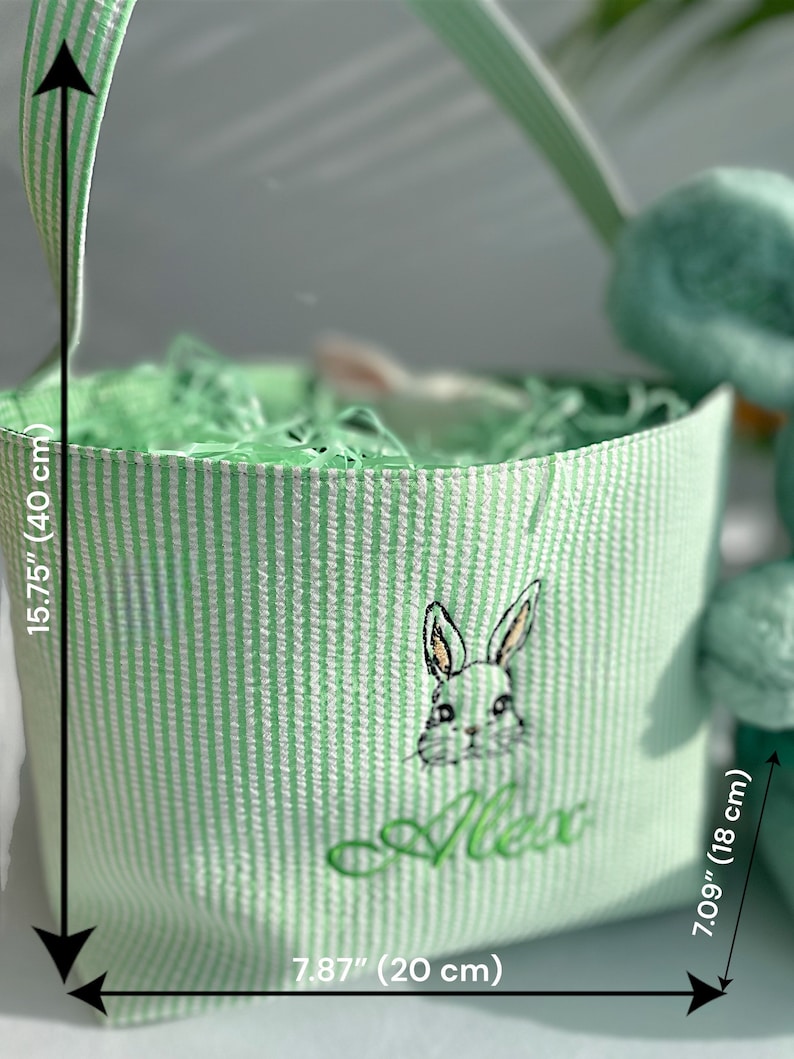 May include: Green and white striped Easter basket with a green bunny and the name "Alex" embroidered on the front. The basket is 15.75 inches tall and 7.87 inches wide.