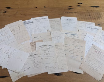 May include: A collection of vintage paper documents with handwritten text. The documents are mostly white with black ink and some have faded brown edges. The documents are scattered on a wooden surface.