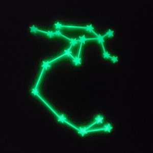May include: A green glow-in-the-dark constellation wall decal in the shape of the zodiac sign Sagittarius.