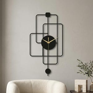 May include: A black metal wall clock featuring an asymmetrical geometric frame made of interconnected rectangles. The clock face is a solid black circle with thin gold hands, and a small black circular pendulum hangs from the bottom.