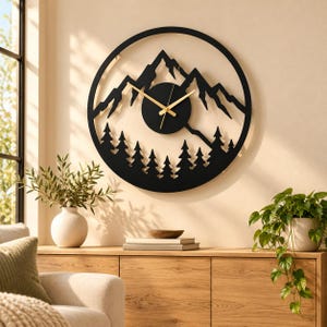 May include: A circular wall clock featuring a black metal frame with a cutout design of mountain peaks and a forest of pine trees. The clock face is a solid black circle positioned in the center, equipped with thin, gold-colored hour and minute hands.