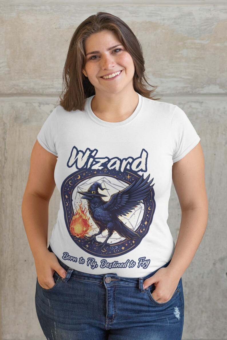 May include: White t-shirt with a black raven holding a flame in a blue and white circle with the word "Wizard" above it and the text "Born to Fly, Destined to Fly" below it.
