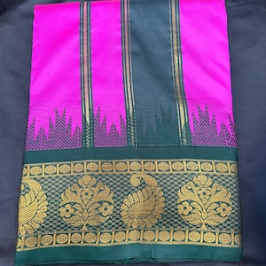 Op de afbeelding: Een roze en zwarte zijden sari met een groene rand. De rand heeft een gouden paisley-ontwerp.