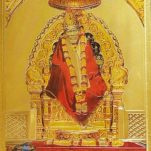 Puede incluir: Una imagen dorada de una figura religiosa sentada en un trono con un dosel dorado arriba. La figura lleva una túnica roja y un collar de oro. El fondo es un patrón dorado.