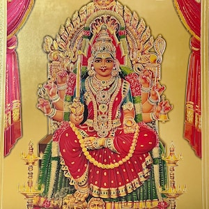 May include: A colorful painting of a Hindu goddess sitting on a throne with a golden background. She is wearing a red and gold sari and has four arms. She is holding a sword in one hand and a bell in another. There are two heads at her feet.