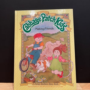 May include: A yellow book cover with the title "Cabbage Patch Kids Making Friends" in green and yellow lettering. The cover features an illustration of a boy riding a red and white bicycle, a girl jumping rope, and a white and brown bulldog. The book is a Parker Brothers Story Book by Kathleen N. Daly with illustrations by Maryann Cocca-Leffler.