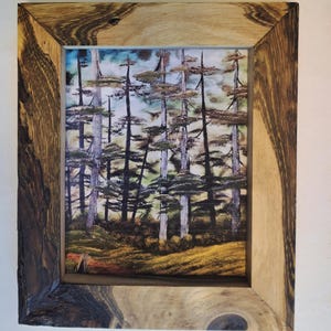 May include: A framed landscape art print featuring a forest scene with tall trees and a colorful sky. The frame is made of natural wood with a unique grain pattern, adding a rustic touch to the artwork.
