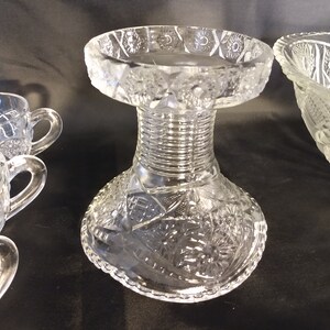 Puede incluir: Un juego de ponchera de cristal transparente con base de pedestal y cuatro tazas. La ponchera y las tazas tienen un dise&ntilde;o de cristal tallado.