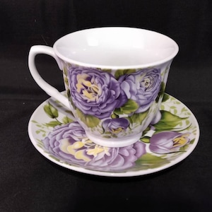 Taza de té y platillo de porcelana con rosa morada y repollo rosa