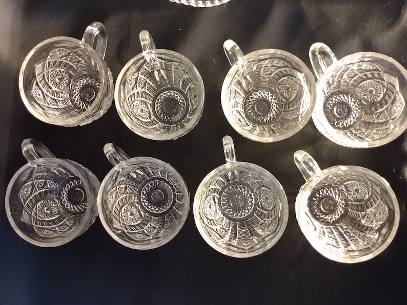 Puede incluir: Ocho tazas de vidrio transparente con un patr&oacute;n decorativo. Las tazas tienen un asa y son perfectas para servir bebidas.