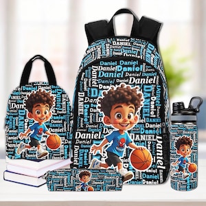 Könnte beinhalten: Ein passendes Schulset mit Rucksack, Lunchpaket, Federmäppchen und Wasserflasche. Jeder Artikel ist mit einem Cartoon-Jungen mit Basketball, dem Namen "Daniel" in einem sich wiederholenden Muster und einem blau-schwarzen Farbschema verziert.