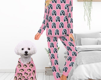 Può includere: Pigiama rosa con un motivo ripetuto di un muso di cane. Un cane bianco che indossa una parte superiore del pigiama abbinata con un motivo ripetuto di un viso umano.