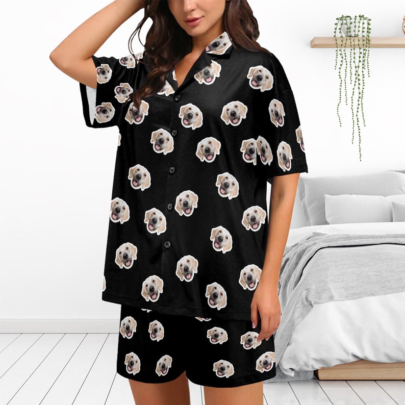 Peut inclure: Ensemble pyjama noir avec une chemise &agrave; manches courtes boutonn&eacute;e et un short assorti. Le tissu pr&eacute;sente un motif r&eacute;p&eacute;t&eacute; de visage de chien.