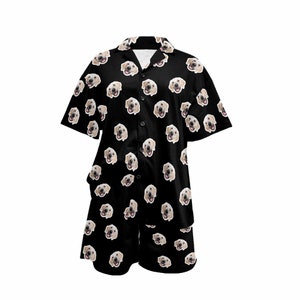 Peut inclure: Ensemble pyjama noir avec une chemise &agrave; manches courtes boutonn&eacute;e et un short assorti. Le tissu pr&eacute;sente un motif r&eacute;p&eacute;t&eacute; de visage de chien.