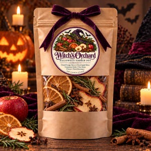 Pode incluir: Uma bolsa de papel castanho contendo uma mistura para panela de fervura de Halloween rotulada como Witch's Orchard. Os ingredientes visíveis através da janela transparente incluem fatias de laranja, maçã, paus de canela, anis estrelado, cravos e alecrim.