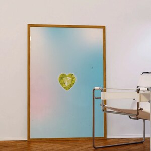 May include: A framed print with a light blue, pink, and white gradient background. A green geometric heart shape is centered on the print.
