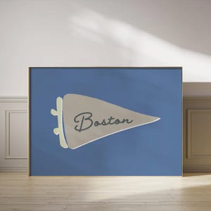 Könnte beinhalten: Ein blaues und beiges Wimpel mit dem Wort "Boston" in Schwarz darauf. Der Wimpel befindet sich auf einem blauen Hintergrund.