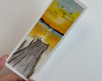 May include: Watercolor painting of a wooden pier extending into a lake at sunset. The sky is a vibrant orange and yellow, with a few birds flying overhead.
