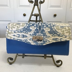Cartera de mano Necessary, vinilo azul cielo con impresión en lienzo a juego
