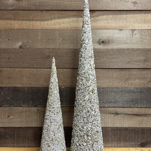 May include: A set of three ceramic mugs with a speckled, matte finish. The mugs are in shades of cream, light gray, and dark gray. Each mug has a simple, minimalist design and a rounded handle.