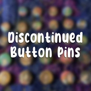 Op de afbeelding: Een assortiment knoopspelden in verschillende kleuren, waaronder groen, oranje en blauw, wordt getoond tegen een wazige, donkerpaarse achtergrond. De tekst "Discontinued Button Pins" staat prominent in het wit, wat context geeft aan de collectie.