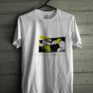 May include: White t-shirt featuring a black and white image of a band, with the text "Jane's Addiction" printed below the image.