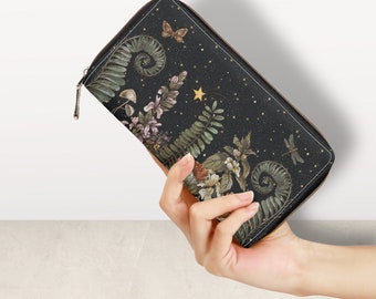 May include: A black zippered wallet with a floral and star design. The design features a variety of flowers, leaves, and a star on a black background.