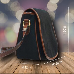May include: Black shoulder bag with brown leather trim and strap. The bag measures 10.24 inches wide, 8.66 inches high, and 4.13 inches deep. Features gold-colored hardware and a curved design.