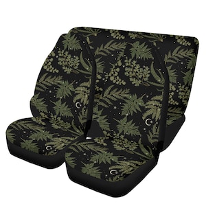 May include: A set of four black car seat covers with a green fern and crescent moon pattern on a black background.