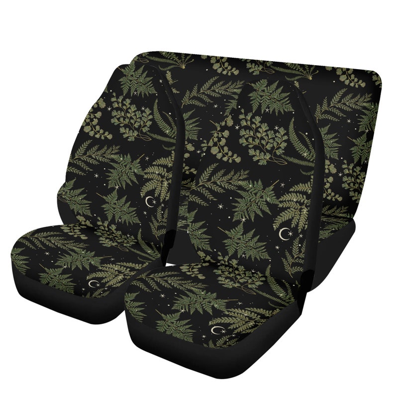 May include: A set of four black car seat covers with a green fern and crescent moon pattern on a black background.