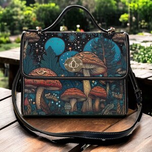 May include: A black leather satchel with a shoulder strap. The bag features a mushroom and forest scene design with blue and green colours.
