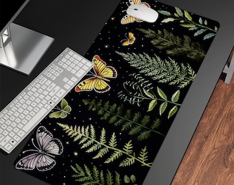 Peut inclure: Un tapis de souris noir avec un fond sombre orné d'un motif répétitif de feuilles vertes et de papillons. Les papillons sont dans des tons de jaune, orange et violet.
