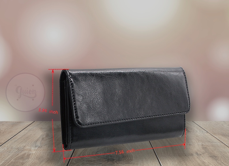 May include: A black leather wallet with a fold-over flap and a stitched edge. The wallet measures 7.56 inches wide and 3.94 inches tall.