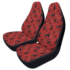 May include: Two red car seat covers with a black cat and jack-o-lantern pattern.