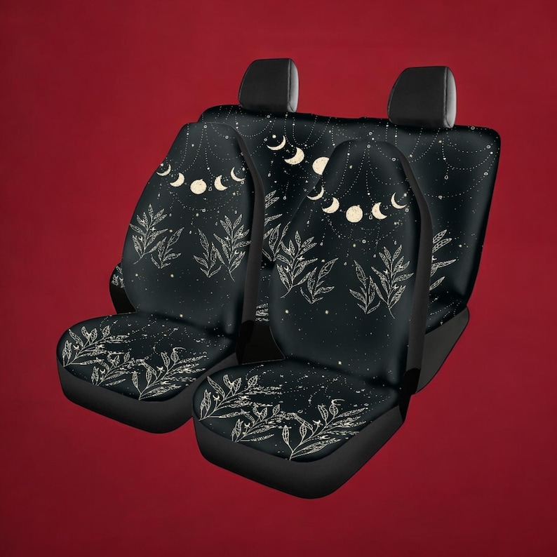 Puede incluir: Fundas para asientos de coche negras con un dise&ntilde;o celestial que presenta lunas blancas, estrellas y hojas sobre un fondo negro.