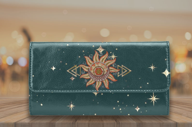 May include: A teal blue leather wallet with a gold sun and moon design and gold stars.