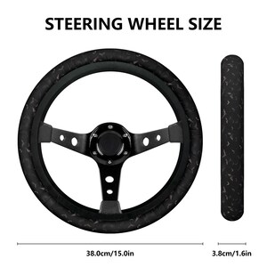 Pode incluir: Volante preto com um padr&atilde;o de morcego preto e branco. O volante tem 38,0 cm de di&acirc;metro e a pega tem 3,8 cm de di&acirc;metro.