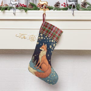 May include: A Christmas stocking with a fox design. The stocking features a blue background with a fox illustration, stars, and trees. The top of the stocking has a red, green, and white plaid pattern. The stocking is hanging from a white mantelpiece.