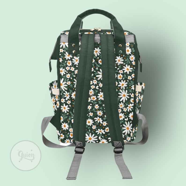 Peut inclure: Un sac &agrave; dos vert fonc&eacute; avec un motif floral de marguerites blanches. Le sac &agrave; dos a des bretelles r&eacute;glables et une fermeture &agrave; glissi&egrave;re.