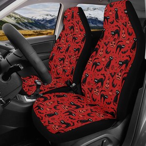 May include: Two red car seat covers with a black and orange Halloween pattern featuring black cats, pumpkins, bats, and stars.
