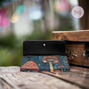 May include: A black leather wallet with a mushroom print. The wallet is open and the inside is black leather. The print features mushrooms in shades of red, orange, yellow, and blue on a dark blue background.