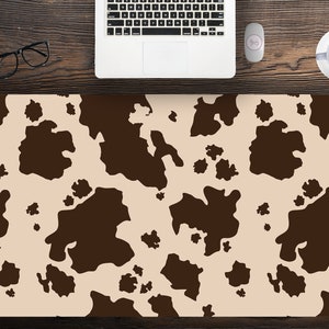 Könnte beinhalten: Ein braunes und beiges Kuhfellmuster. Das Muster ist ein sich wiederholendes Design aus braunen Flecken auf einem beigen Hintergrund.