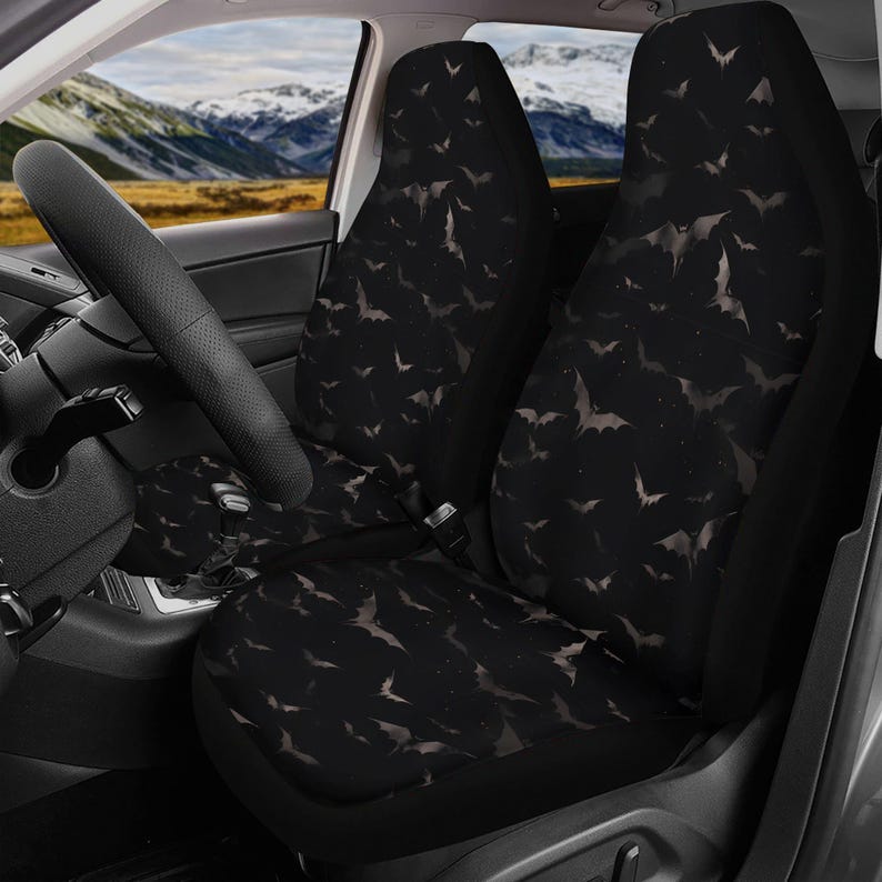 Pode incluir: Capas de assento de carro pretas com um padr&atilde;o de morcegos brancos sobre um fundo escuro. As capas s&atilde;o feitas de um tecido macio e confort&aacute;vel e s&atilde;o projetadas para proteger os assentos do seu carro de sujeira, derramamentos e desgaste.