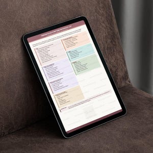 May include: A black tablet displaying a reference list titled "Fibromyalgia Symptoms Reference List." The list is organized with colored sections and text. The tablet rests on a brown surface.