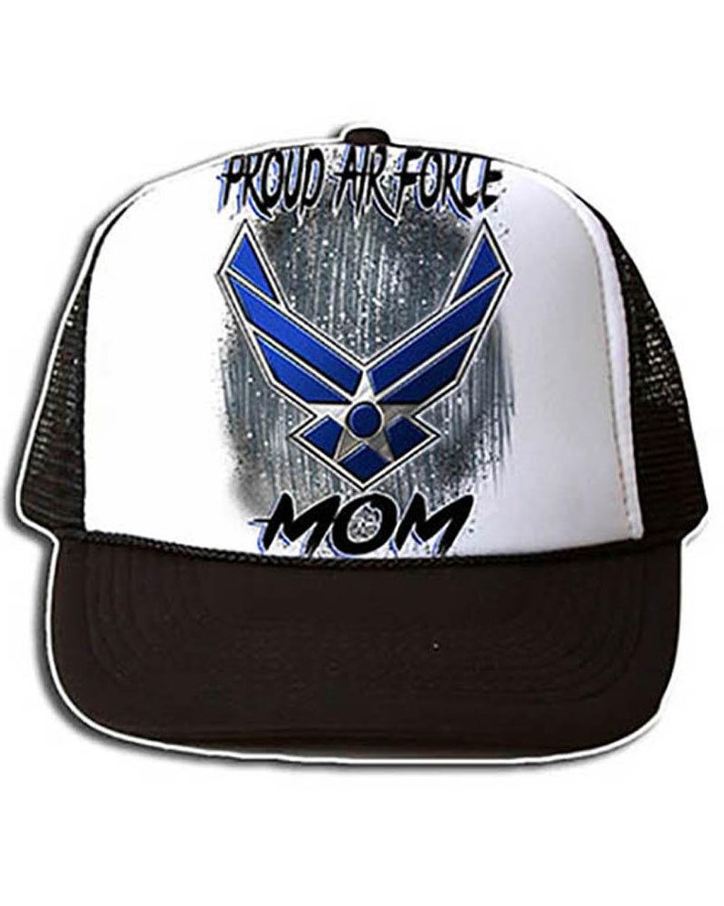 May include: A white and black trucker hat with a blue Air Force logo and the words "Proud Air Force Mom" on the front.