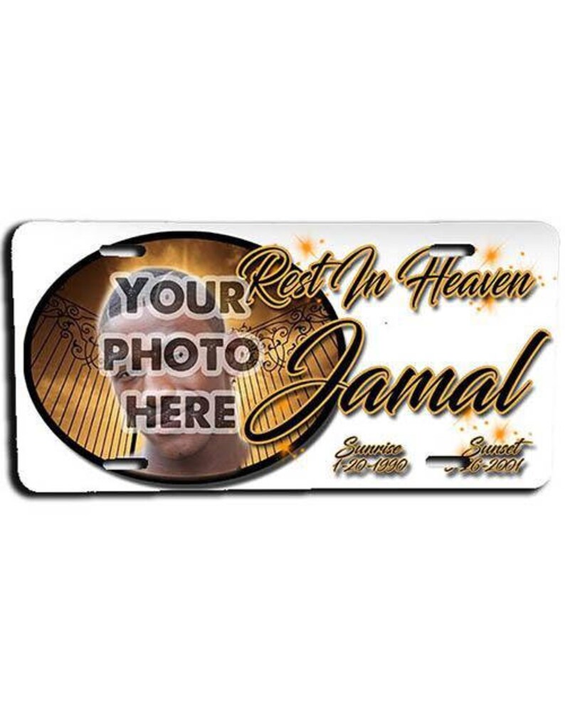 May include: A gold and white memorial license plate with a photo placeholder, the text "Rest In Heaven Jamal", and the dates "Sunrise 1-20-1990" and "Sunset 2-6-2001".